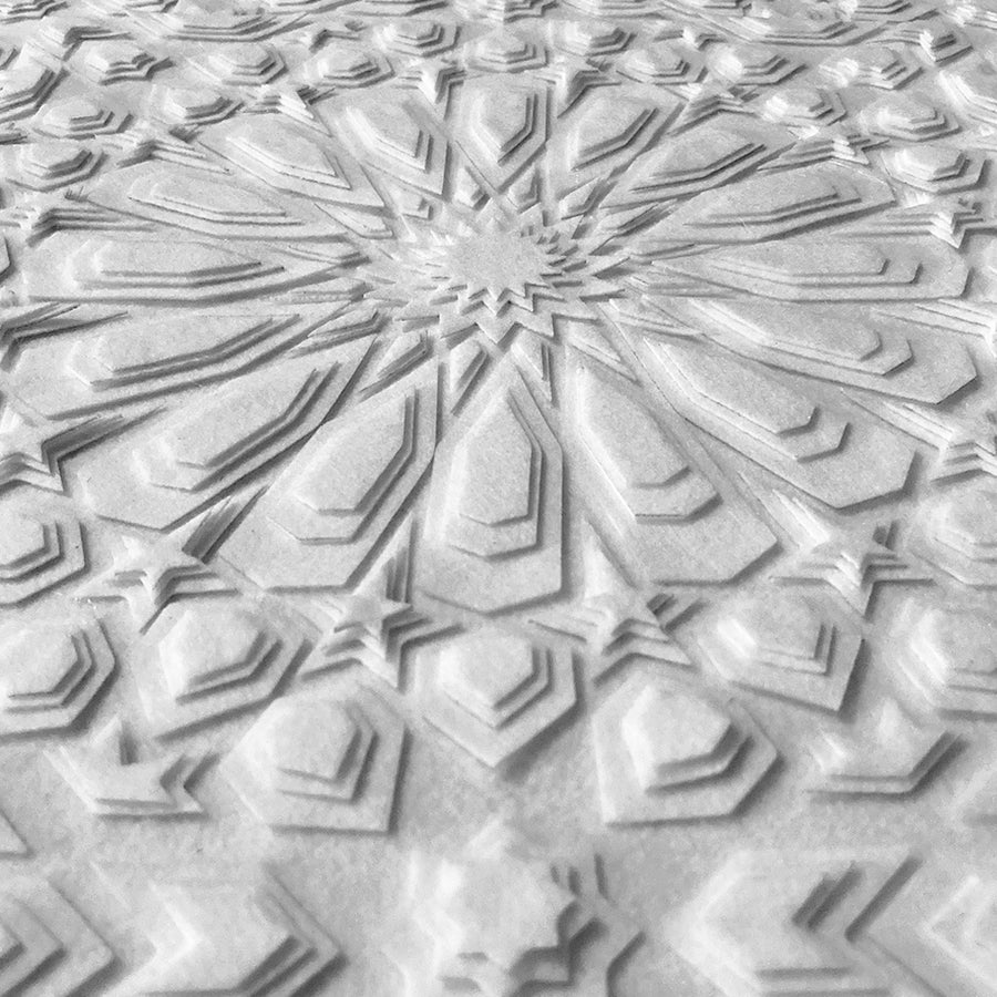 A closer look at the detail in this layered, white, laser cut textile design by Jennifa Chowdhury for Shiver Art Gallery, shown from an angle.
