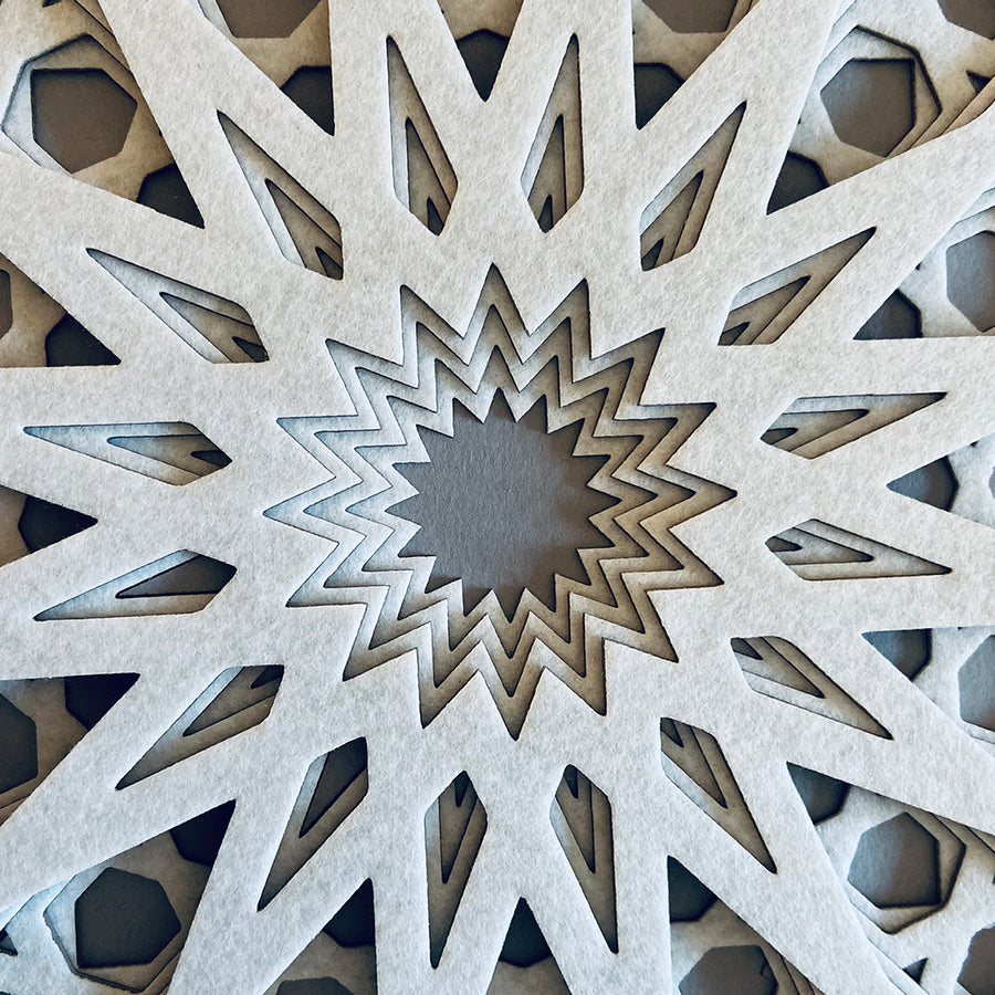 A zoomed in view of the centre of this intricate, white, laser cut textile design by Jennifa Chowdhury showing the intricate detail.