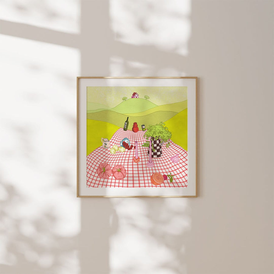 Beautiful illustration artwork of a picnic on a hill by Elisa Grasso, in a square picture frame on a white wall with a shadow from the window cast over them.