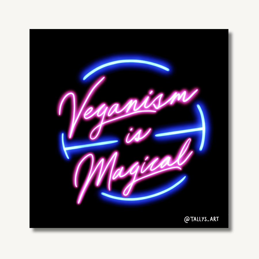Digital art print by Tally Walker Warne on an off-white background and a drop shadow to highlight it’s a print. Artwork features the words ‘veganism is magical’ in neon pink and blue on a black background to look like a neon sign glowing in the dark.