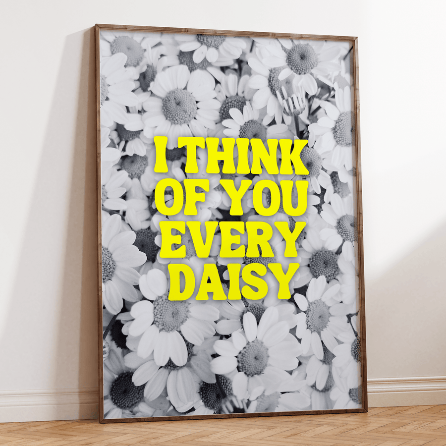 Black and white photograph of daisies, with neon yellow text overlay saying ‘I think of you every daisy’. Art Print in a large thin dark wooden frame.