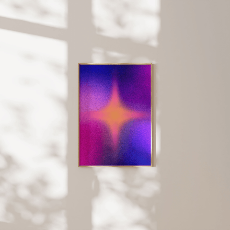 Art print of a colourful star aura with a pink and blue gradient background.The print is framed in a thin light wooden frame and mounted on a white wall.