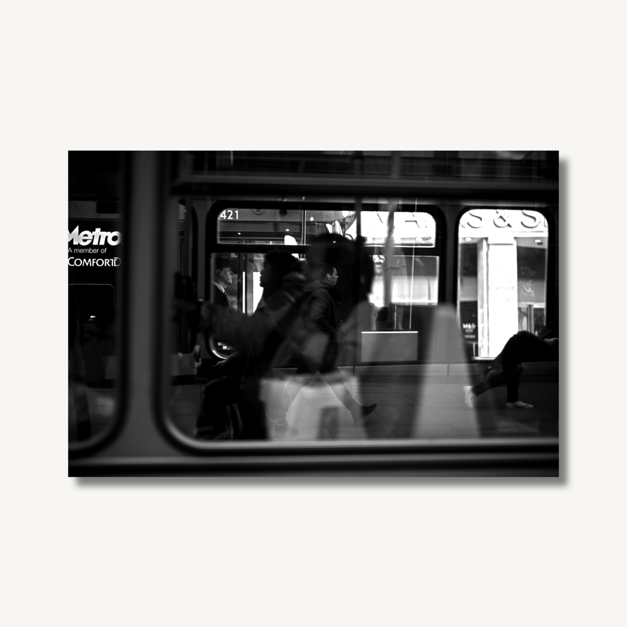 Black and white photograph through a bus window on Oxford Street, where you can see through the bus, into another bus.