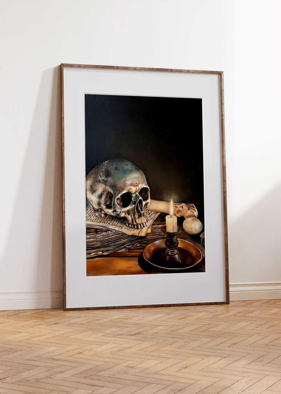 ‘Skull by candlelight’ by Charlotte Witts A3 art print in a white window mount inside a thin dark wood frame.
