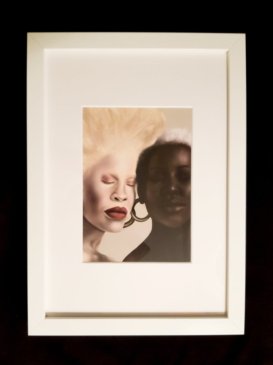 Digital painting of 2 beautiful black women, one is albino with pale skin and a blonde afro and the other is dark skinned with short white hair. Both are wearing large, gold, hoop earrings.