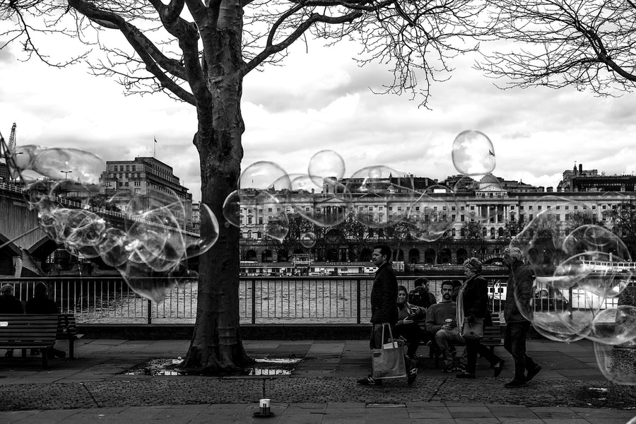 Black and white, high contrast photograph of a line of bubbles, near the Thames in central London.