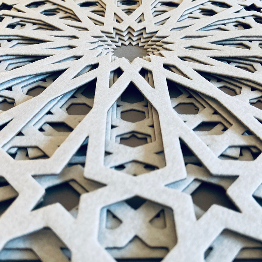 A closer look at the detail in this intricate, white, laser cut textile design by Jennifa Chowdhury for Shiver Art Gallery, shown from an angle.