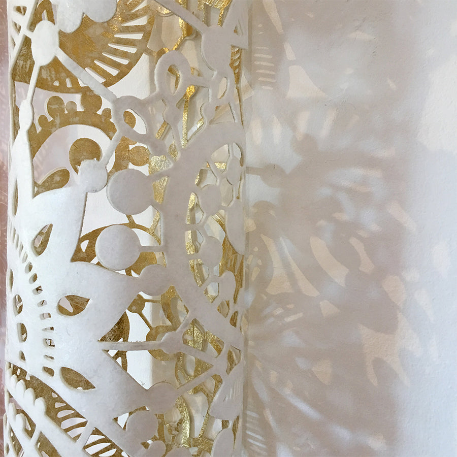 A close up showing the detailed design on this white and gold textile sculpture by Jennifa Chowdhury, created to portray peace, purity and godliness.