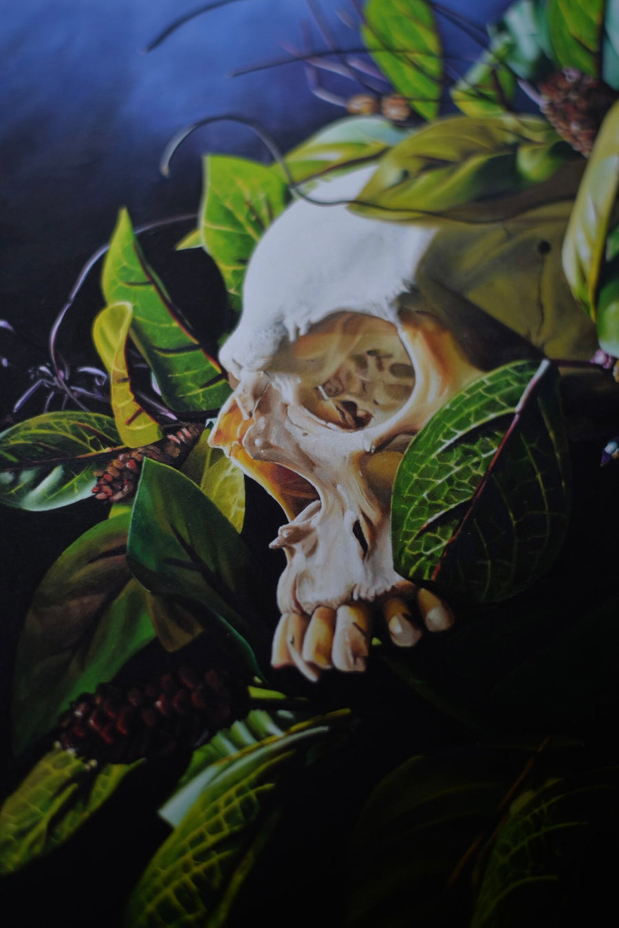 Art print of a traditional style oil painting of a skull with leaves and flowers, on a blue background.